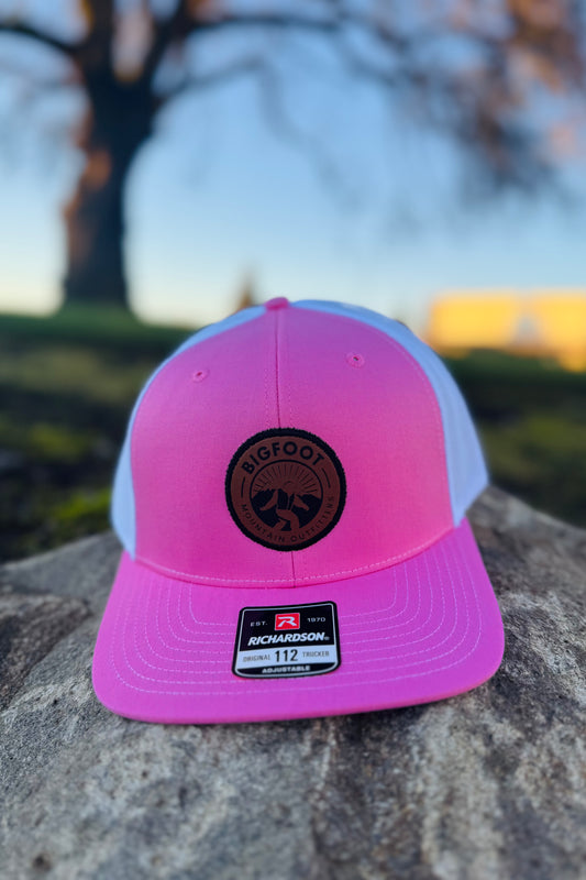 Bigfoot Mountain Outfitters original patch logo mesh back hat in Pink/White, a casual classic trucker hat for sunny days on the water, road trips, festivals and everyday wear