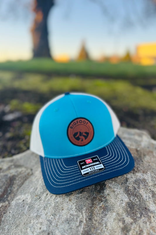 Bigfoot Mountain Outfitters original patch logo mesh back hat in Teal/Navy/Cream, a casual classic trucker hat for sunny days on the water, road trips, festivals and everyday wear